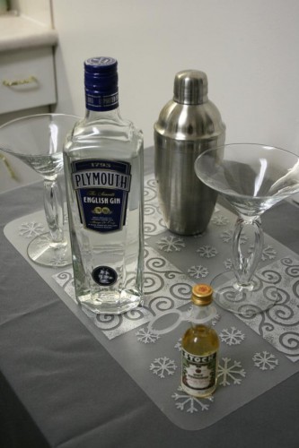 Do we have all the ingredients? Here's our martini set-up: gin, vermouth, a shaker, a "shot glass" repurposed from child's cough syrup and two trendy-looking martini glasses. Sexy!
